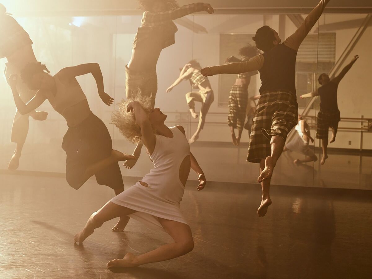 Dancers jumping into the air and tumbling to the ground