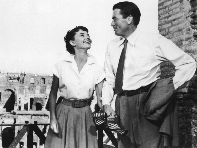 Belgian-born actor Audrey Hepburn holds the hand of American actor Gregory Peck in a still from the film "Roman Holiday," directed by William Wyler in 1953.