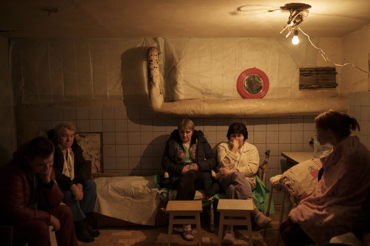 Hospital staff sit in a basement, used as a bomb shelter, during an air raid alarm in Brovary, north of Kyiv, Ukraine, Thursday, March 17, 2022. (AP Photo/Felipe Dana)