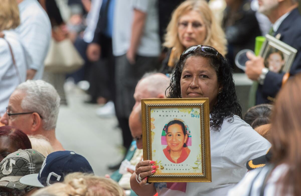 En esta imagen de archivo del 11 de septiembre de 2015, una mujer sostiene una fotografía durante una ceremonia en memoria de los atentados del 11 de septiembre de 2001 contra el World Trade Center en Nueva York. (AP Foto/Bryan R. Smith, Archivo)