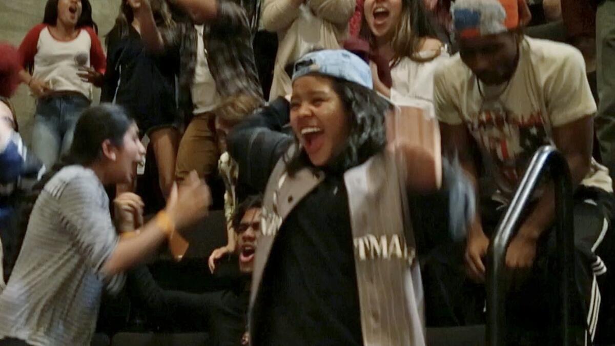 High school senior Vanessa Tahay reacts with her teammates when their team is announced as the winner of the poetry slam.