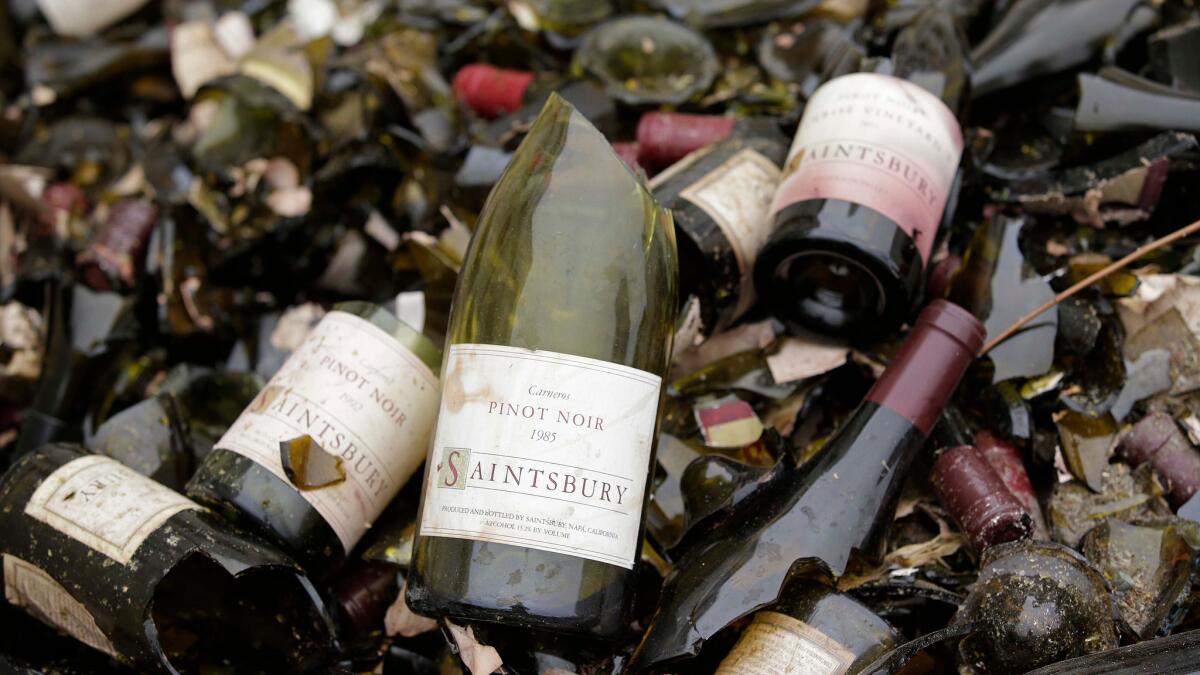 Vintage bottles from the wine library at Saintsbury winery in Napa, Calif., are tossed in a bin after an August 2014 temblor. (Eric Risberg / Associated Press)