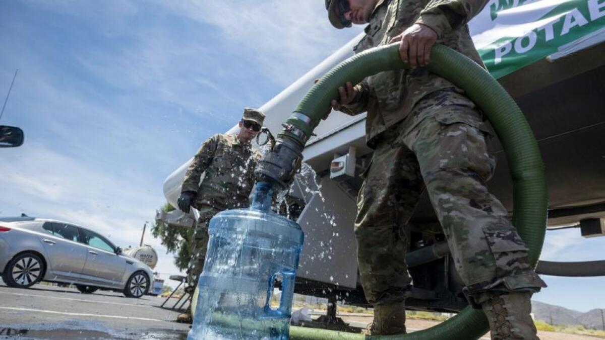 Las tropas de la Guardia Nacional llenan botellas de agua para los residentes en Trona, California, el 9 de julio. (James Quigg / Associated Press)
