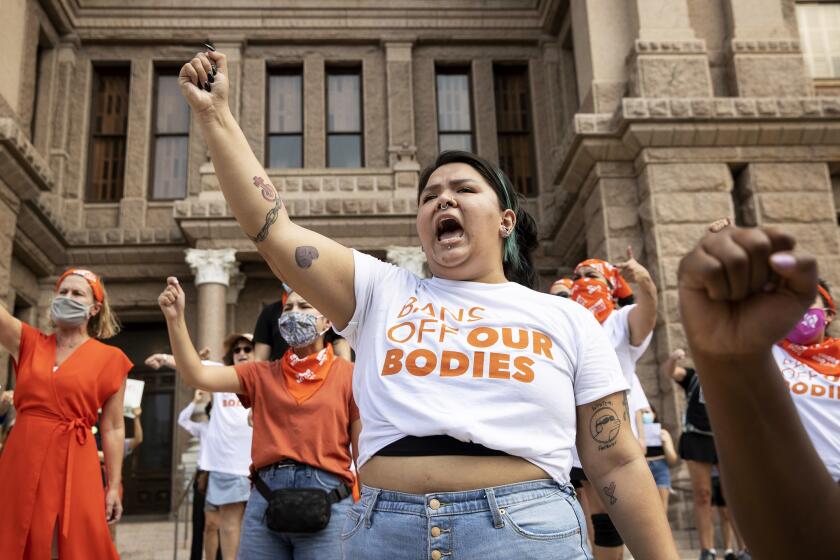 FILE - Leen Garza participates in a protest with others against the six-week abortion ban at the Capitol in Austin, Texas, on Wednesday, Sept. 1, 2021. The Justice Department is asking a federal court in Texas to issue a temporary restraining order or a preliminary injunction against a new state law that bans most abortions in Texas. The emergency motion filed Tuesday night, Sept. 14 says a court can issue such an order as a means of preventing harm to parties involved before the court can fully decide the claims in the case. (Jay Janner/Austin American-Statesman via AP, File)