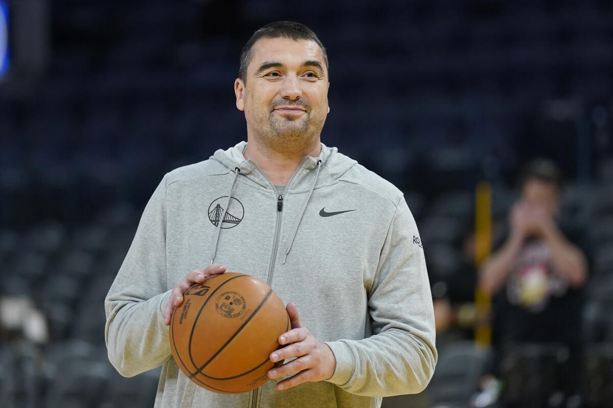 Warriors assistant coach Dejan Milojevic smiles during an NBA preseason basketball game against the Nuggets.