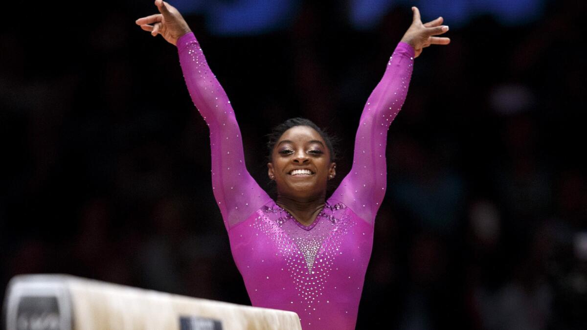 American Simone Biles is all smiles after completing her routine in the balance beam on Sunday.