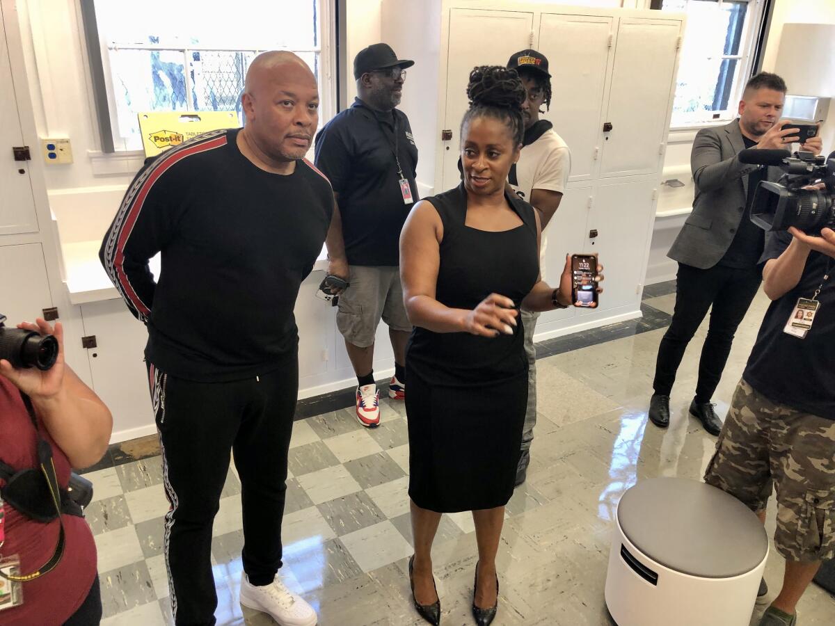 Principal Akilah Calhoun, right, brings Andre "Dr. Dre" Young to a classroom.