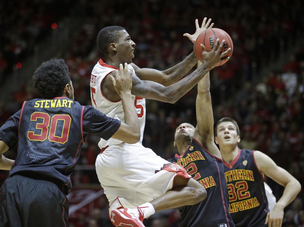 Utah guard Delon Wright heads to the basket as USC's Elijah Stewart (30) and Julian Jacobs (12) defend. The Trojans lost to the No. 10 ranked Utes, 79-55.