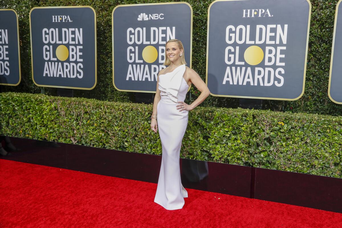 Reese Witherspoon arriving at the 2020 Golden Globe Awards red carpet in a white ruffled gown.