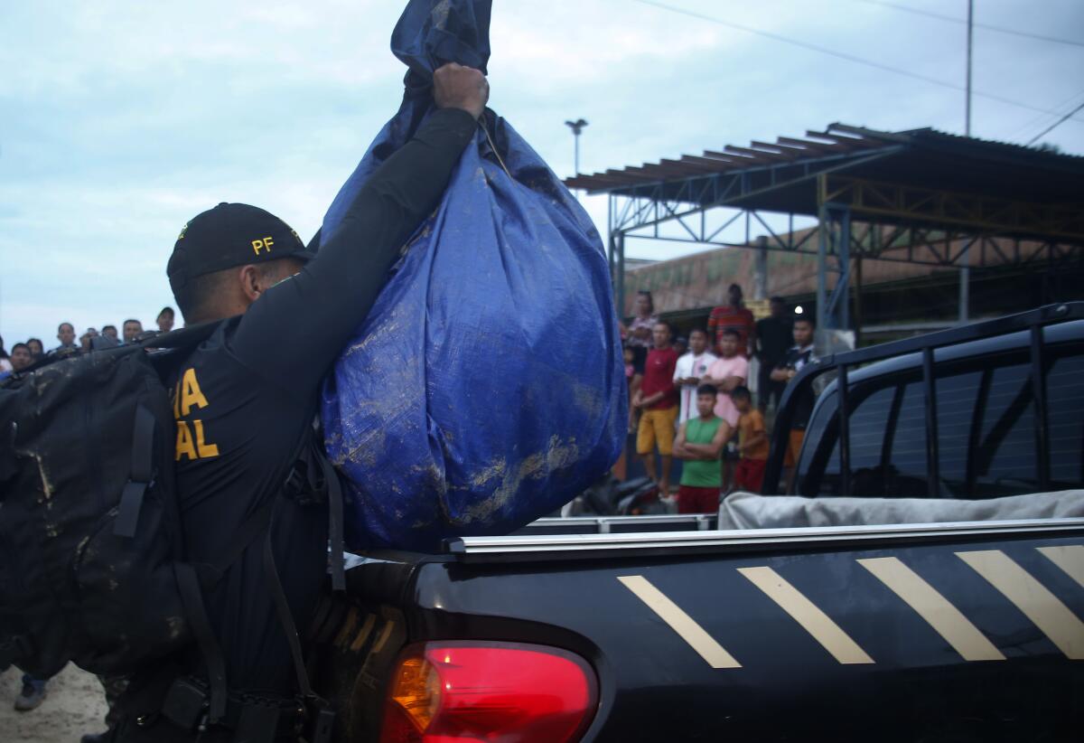 Police officer hoisting a sack into a truck