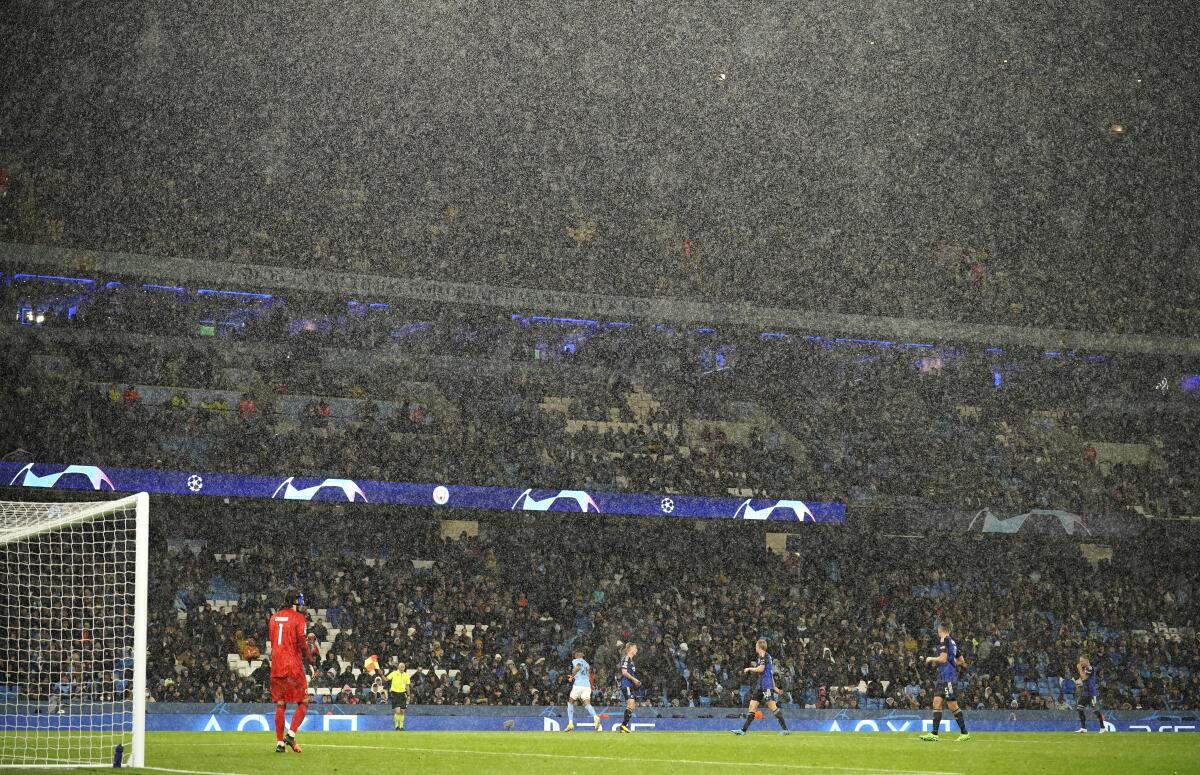 The rain comes down heavily during the Champions League soccer match between Manchester City and FC Copenhagen at the Etihad stadium in Manchester, England, Wednesday, Oct. 5, 2022. (AP Photo/Dave Thompson)
