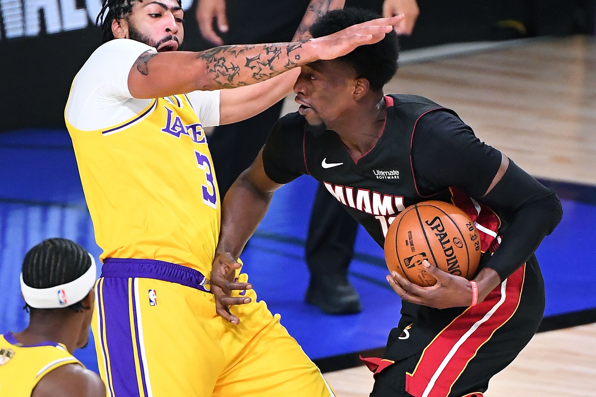 Lakers forward Anthony Davis takes a charge from Heat center Bam Adebayo during Game 4.