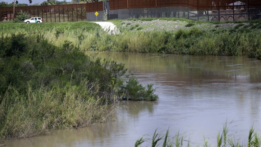 A U.S. Border Patrol vehicle sits above the Rio Grande at the U.S.-Mexico border in Brownsville, Texas.