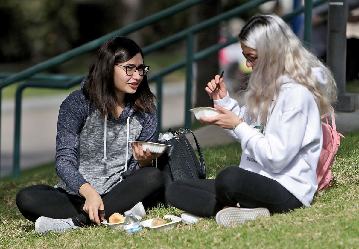 Glendale Community College students Pantea Shahriari, 23, left, and Selia Zakarian, 21, right, enjoy a variety of international food like Persian, Mexican and American, during the GCC International Students Association International Education Week, at the college main plaza in Glendale on Tuesday, Nov. 13, 2018.