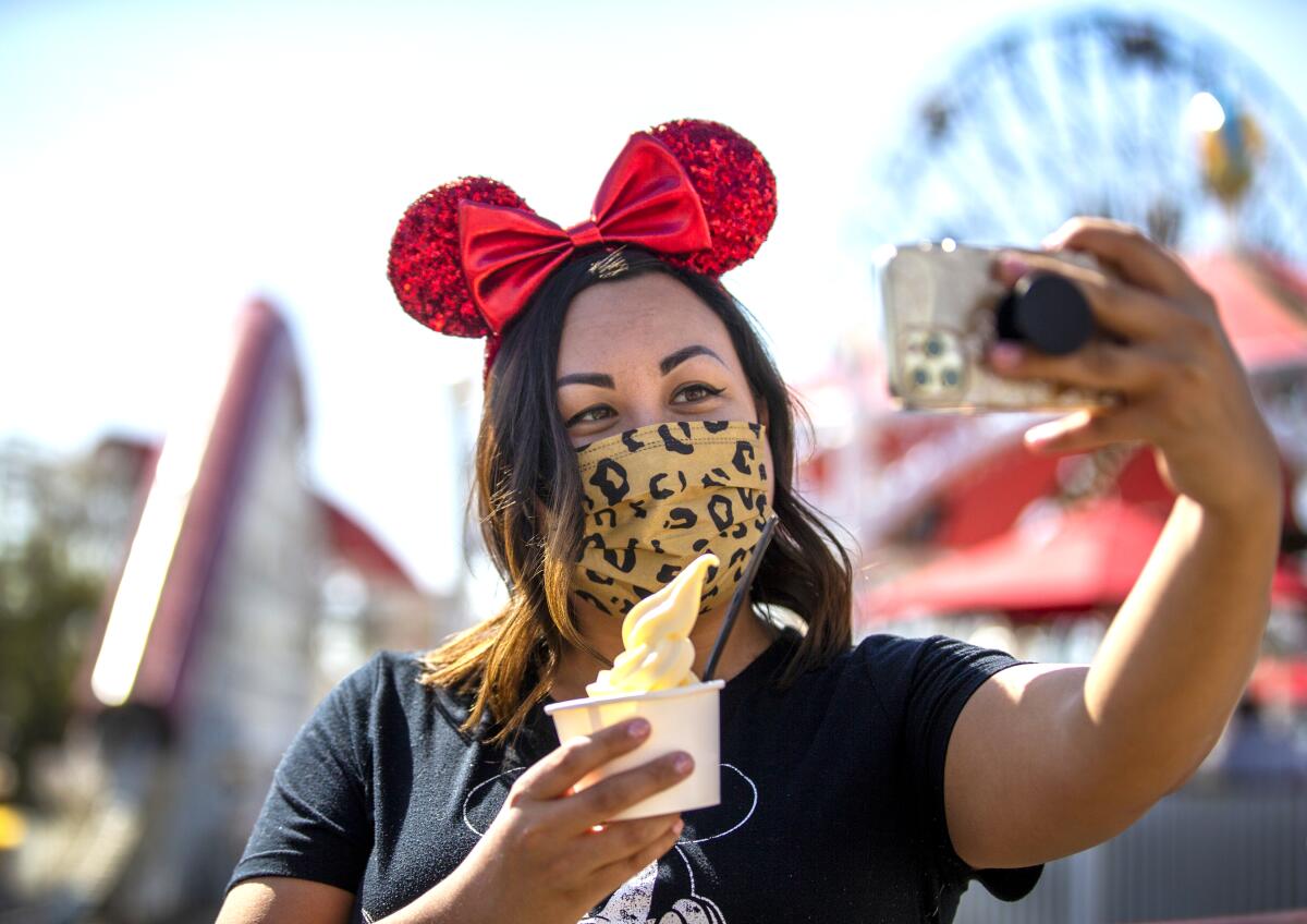 Monica Link, of Sacramento, takes a photo with a Dole Whip at the Adorable Snowman Frosted Treats on Pixar Pier 