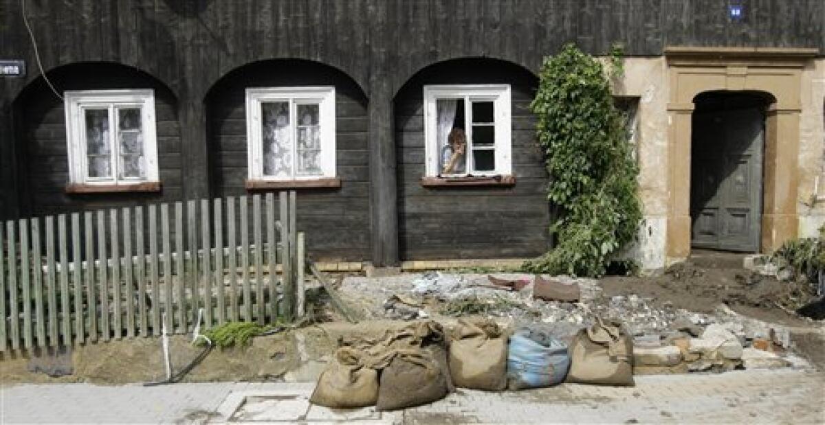 An elderly woman looks out of her window after a flash floods hit the town of Bogatynia, Poland, Sunday, Aug. 8, 2010. The flooding has struck an area near the borders of Poland, Germany and the Czech Republic.(AP Photo/Petr David Josek)