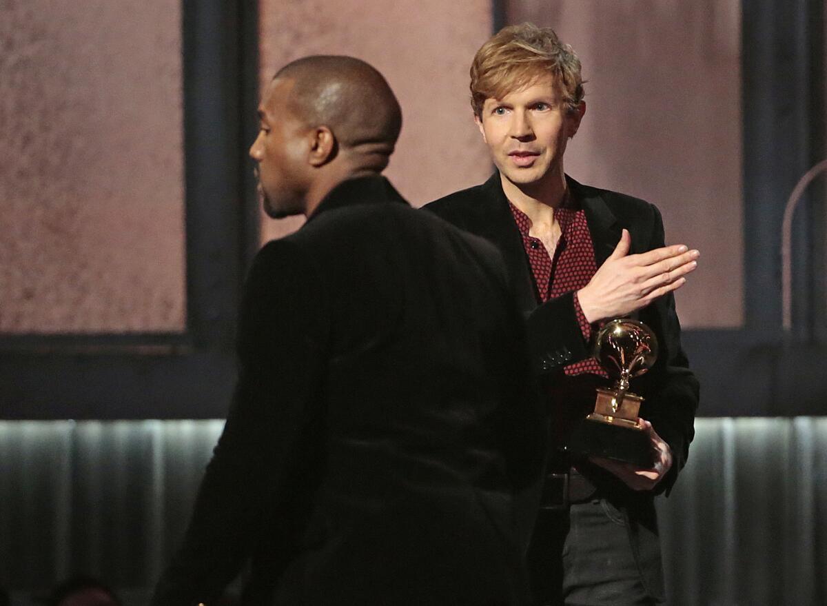 Kanye West, left, avoids contact with an inviting Beck onstage at the Grammys.