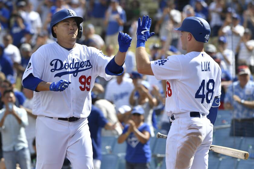 LOS ANGELES, CA - SEPTEMBER 22: Hyun-Jin Ryu #99 of the Los Angeles Dodgers is congratulated by Gavin Lux #48 after hitting the first home run of his career in the fifth inning against the Colorado Rockies at Dodger Stadium on September 22, 2019 in Los Angeles, California. (Photo by John McCoy/Getty Images)