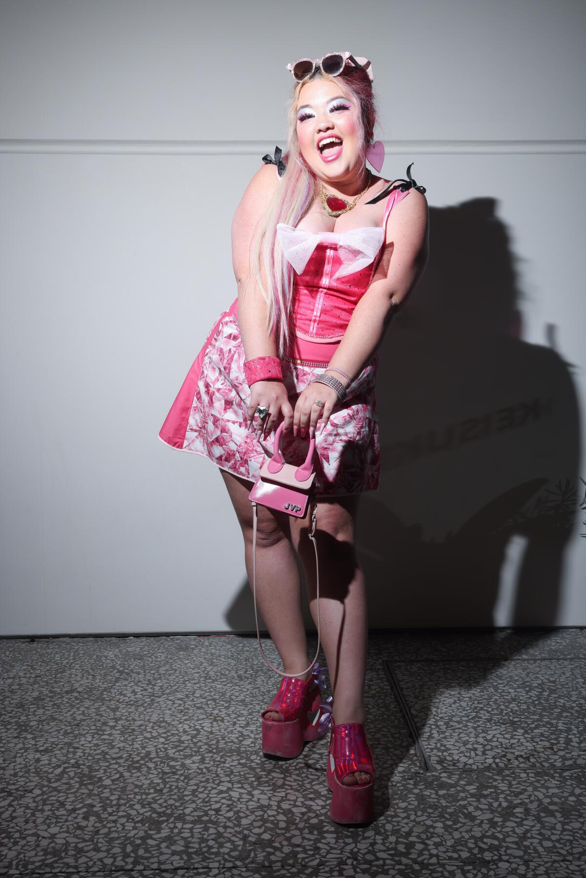  Jasmine Vaughn Perrett, 27, poses in a pink dress and platform pink shoes and pink purse.