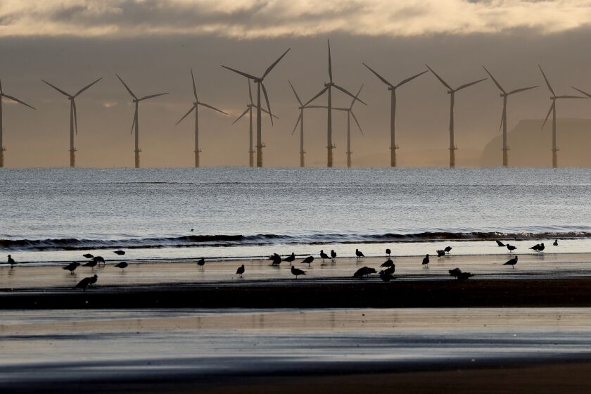FILE - An offshore wind farm is visible from the beach in Hartlepool, England, Tuesday, Nov. 12, 2019. Environmental groups have welcomed a decision by Britain’s Conservative government to lift its opposition to onshore windfarms. But they warn that any benefit will be erased if the government backs plans to open the U.K.’s first new coal mine in three decades. Since 2015 the Conservative government has opposed new wind turbines on land because of local opposition. (AP Photo/Frank Augstein, File)