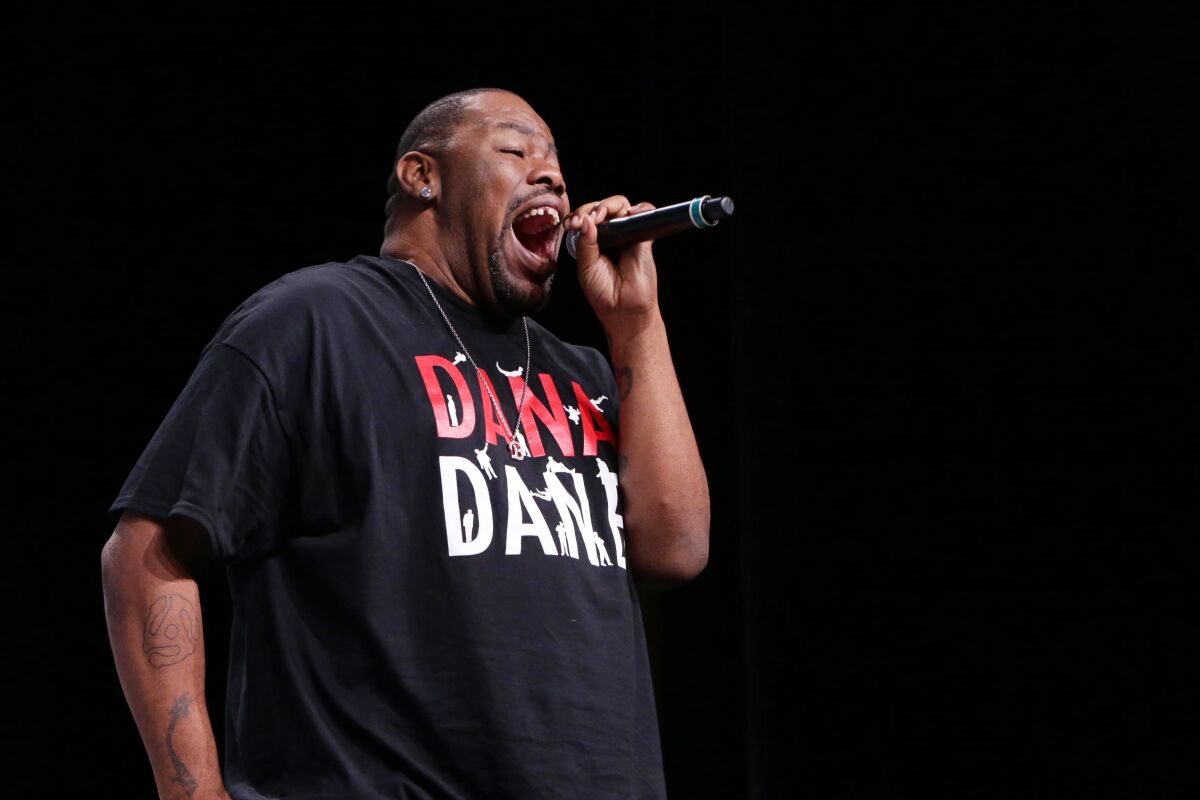 Biz Markie, on stage, holds a microphone.