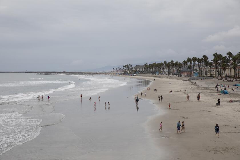 Oceanside, CA - October 07: People enjoy the beach near the Oceanside Pier on Thursday, Oct. 7, 2021 in Oceanside, CA. Tar balls have been reported in Carlsbad from the Orange County oil spill. (Ana Ramirez / The San Diego Union-Tribune)