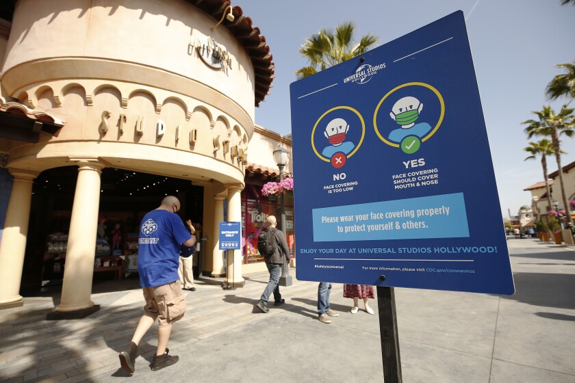 Signage encourages guests to use proper protection as Universal Studios Hollywood welcomed back people in April.