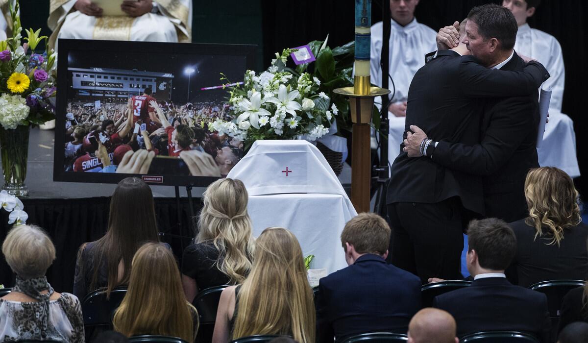 Ryan Hilinski is hugged by his dad Mark Hilinski after speaking at his brother's funeral at Damien High School in January 2018.