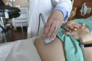 A doctor performs an ultrasound on a pregnant woman