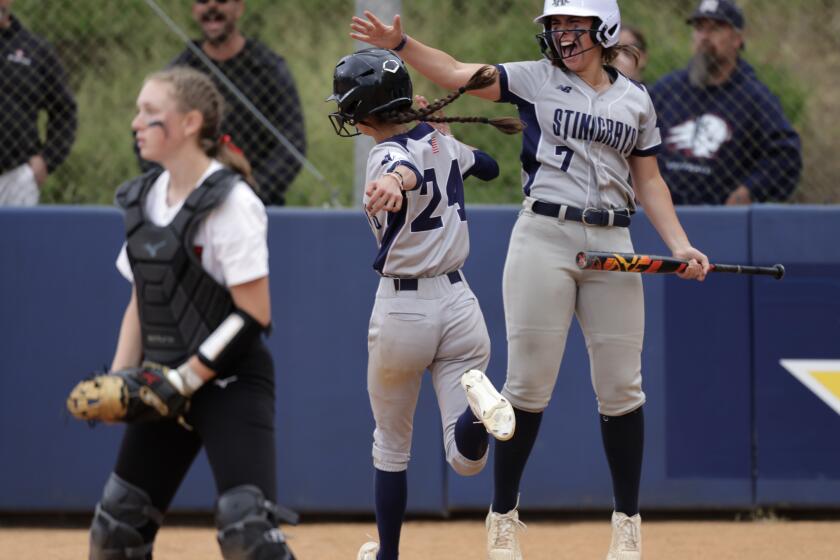 RANCHO SANTA FE, CA - MAY 23, 2024: Coastal Academy's Delylah Ordman celebrates with Aubrey Price after Ordman crossed home plate to score in the eighth inning during the CIF Division IV championship softball game against Santa Fe Christian at UCSD in San Diego on Friday, May 24, 2024.
