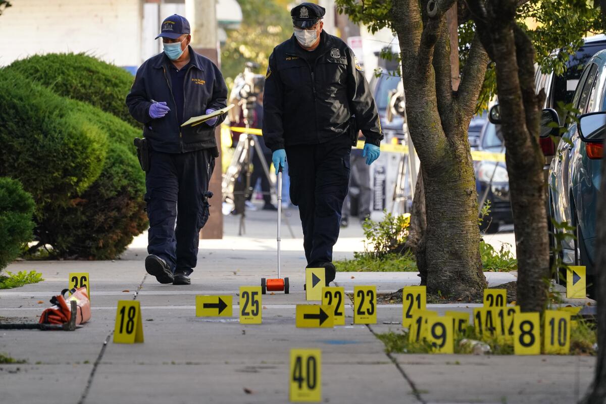 Investigators work the scene where multiple people were shot including police officers when a SWAT team attempted to serve a homicide warrant in Philadelphia, Wednesday, Oct. 12, 2022. The shooting occurred around 6:30 a.m., soon after officers tried to serve the warrant in North Philadelphia. (AP Photo/Matt Rourke)
