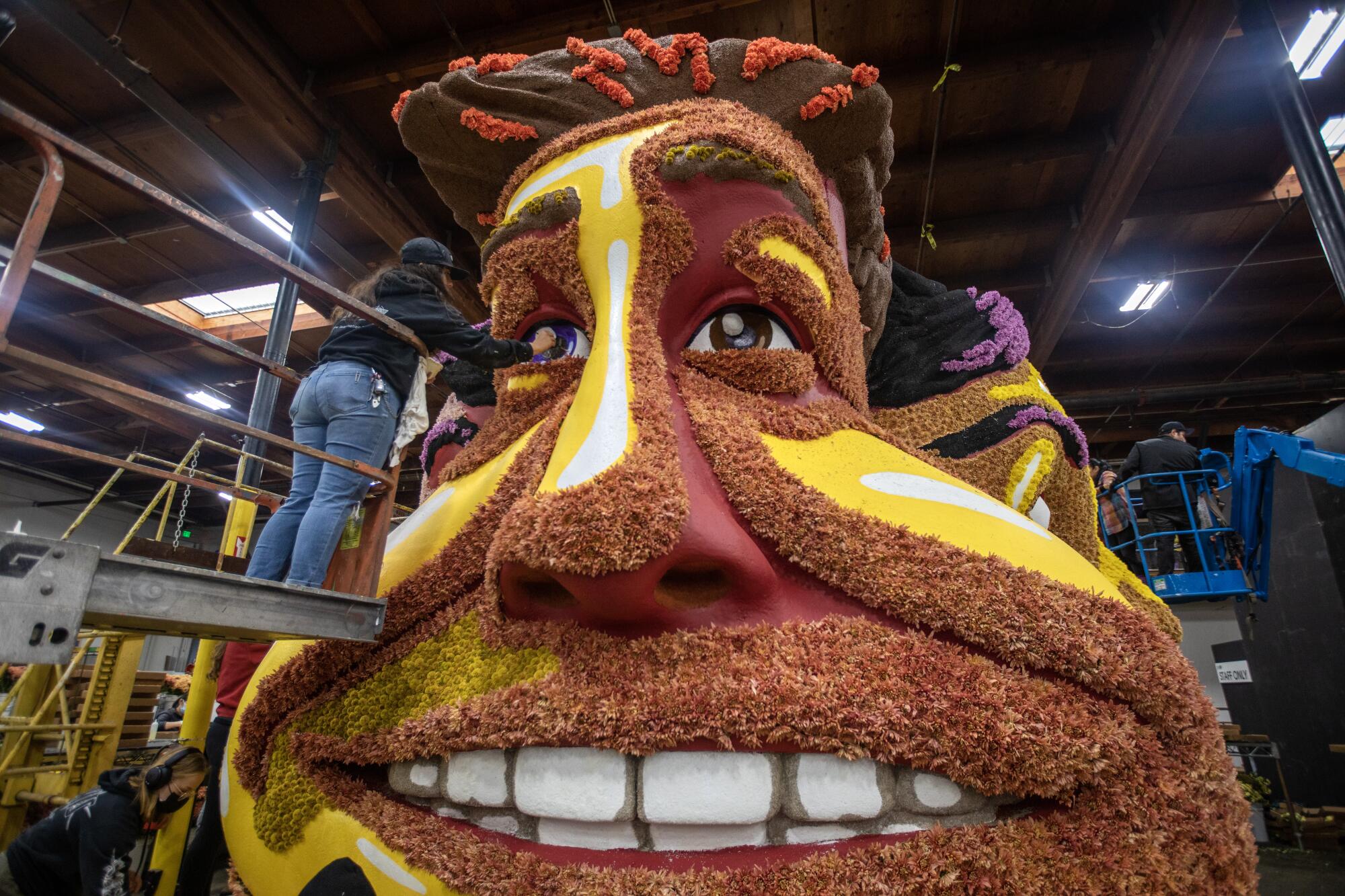 Briana Navarro works on the Snapchat "Wait'll You See This" float inside the Rosemont Pavilion on Saturday.