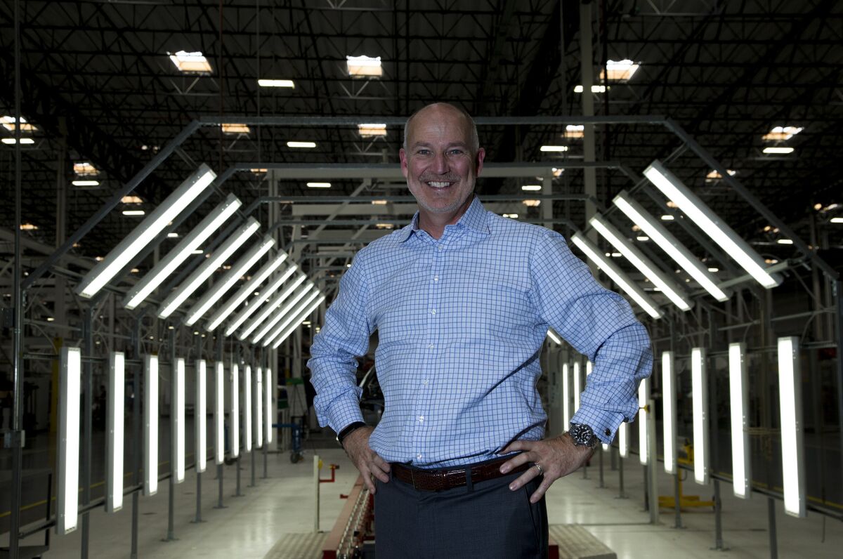 Jim Taylor, chief marketing officer for Karma Automotive, stands in front of a body shop quality control area in the Moreno Valley factory where Karma is building its $100,000-plus hybrid electric luxury sedans.