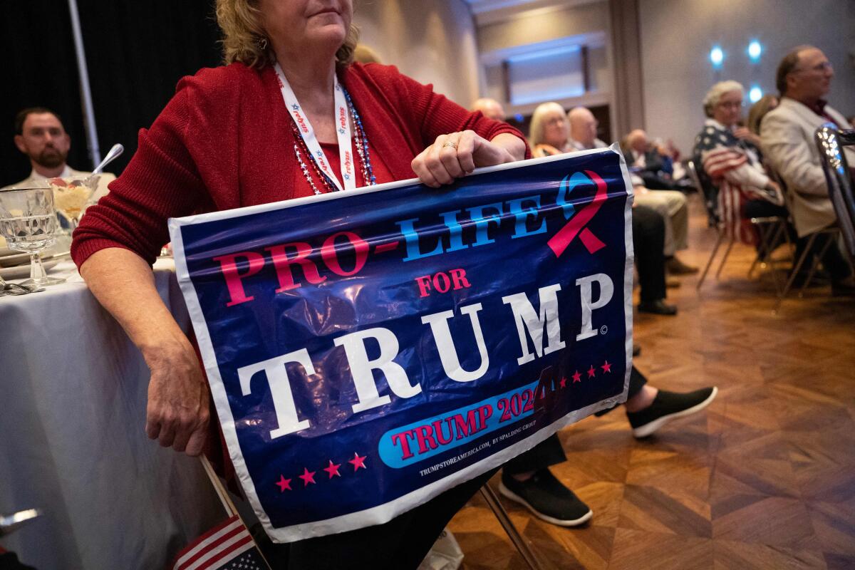 A woman holds a sign saying "Pro-life for Trump"