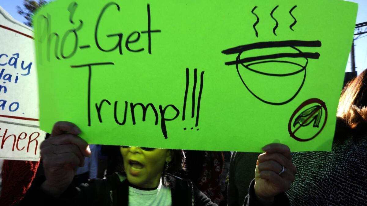 "Pho-Get Trump," states a sign carried by a protester in Little Saigon.