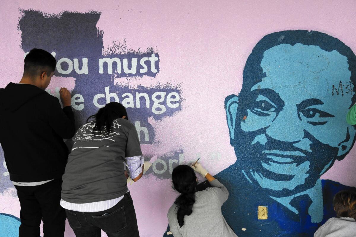 At Woodcrest Elementary in South L.A. on Monday, volunteers painted colorful murals, cleaned classrooms, planted a garden and refurnished weathered benches.