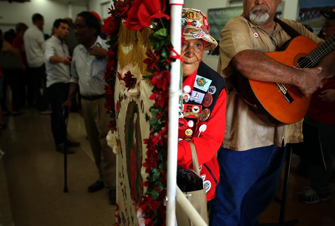 Josefina Flores, 85, a striker with Cesar Chavez in 1965, makes her way through the crowd with a banner during the 50th-anniversary commemoration of the Delano grape strike at the Forty Acres complex.