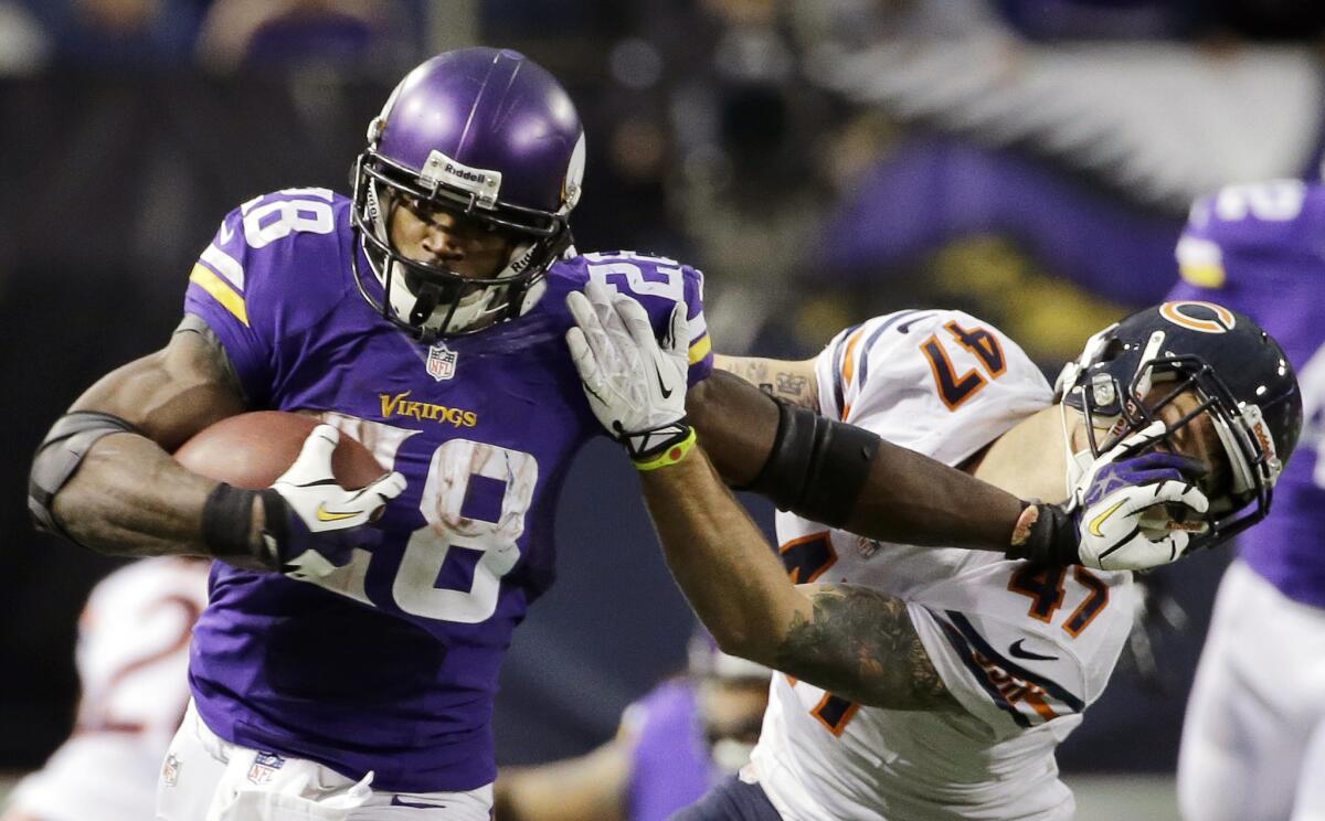 Minnesota running back Adrian Peterson, left, tries to break a tackle from Chicago safety Chris Conte in December.
