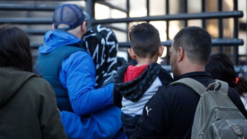 Honduran asylum seekers enter the U.S. on Dec. 18 at San Diego's Otay Mesa port of entry, as seen from Tijuana.