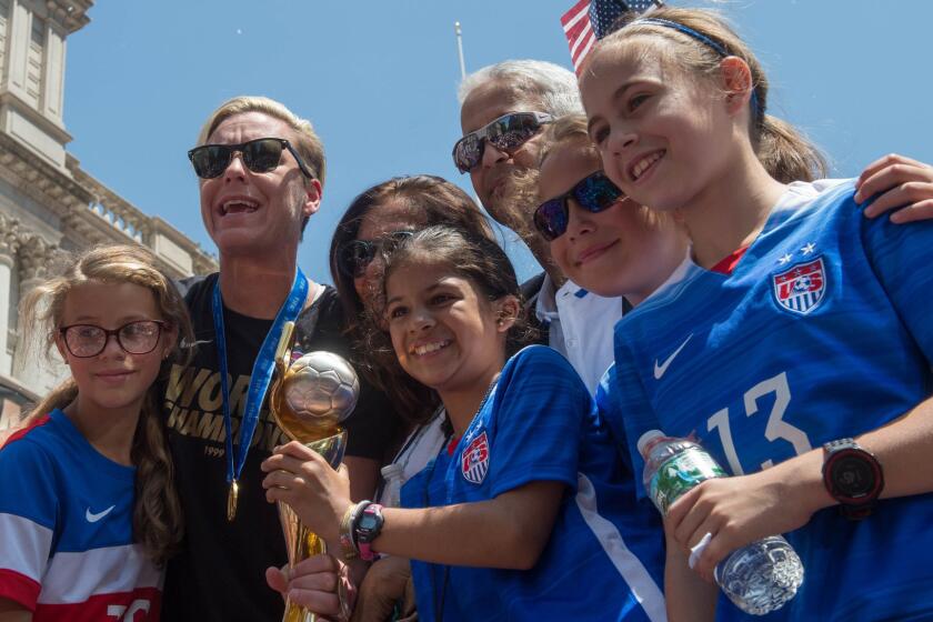 U.S. captain Abby Wambach shares the Women's World Cup trophy with fans as New York Mayor Bill de Blasio during a team championship celebration in New York on Friday.