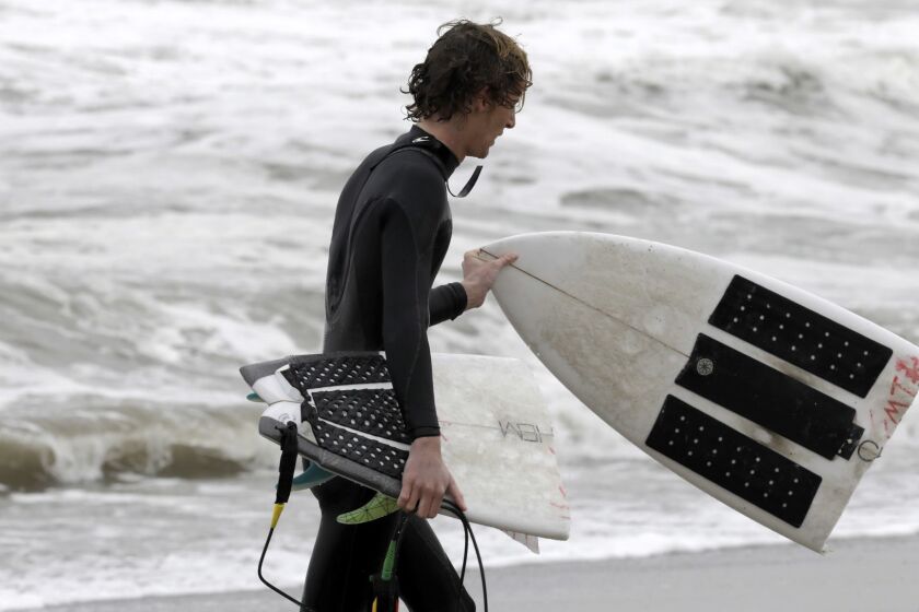 MALIBU, CA-JANUARY 16, 2019: Will Reid, from Torrance Beach, walks out of the water with a broken board after surfing at Zuma Beach in Malibu. Surfers took advantage of the swell brought on by the storm moving into the area. (Katie Falkenberg / Los Angeles Times)