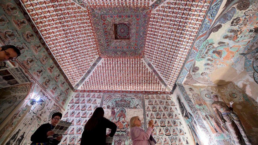 Visitors pass through one of the re-created Mogao Grottoes in the Getty Center exhibition "Cave Temples of Dunhuang: Buddhist Art on China's Silk Road."