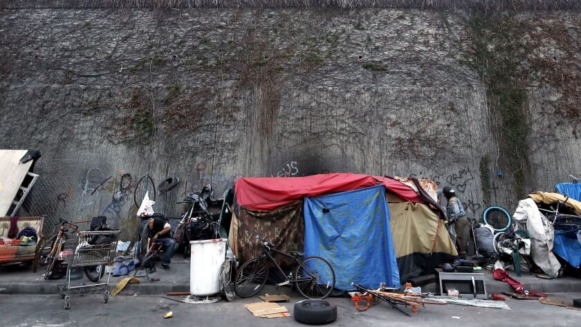 LOS ANGELES, CALIF. - MAY 22, 2018. Homeless people live in tents beside a wall that seperates Gra