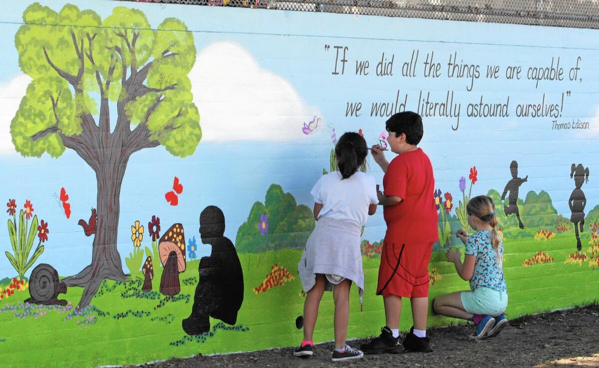 Students help paint a mural at Edison Elementary on Tuesday, Feb. 16, 2016.