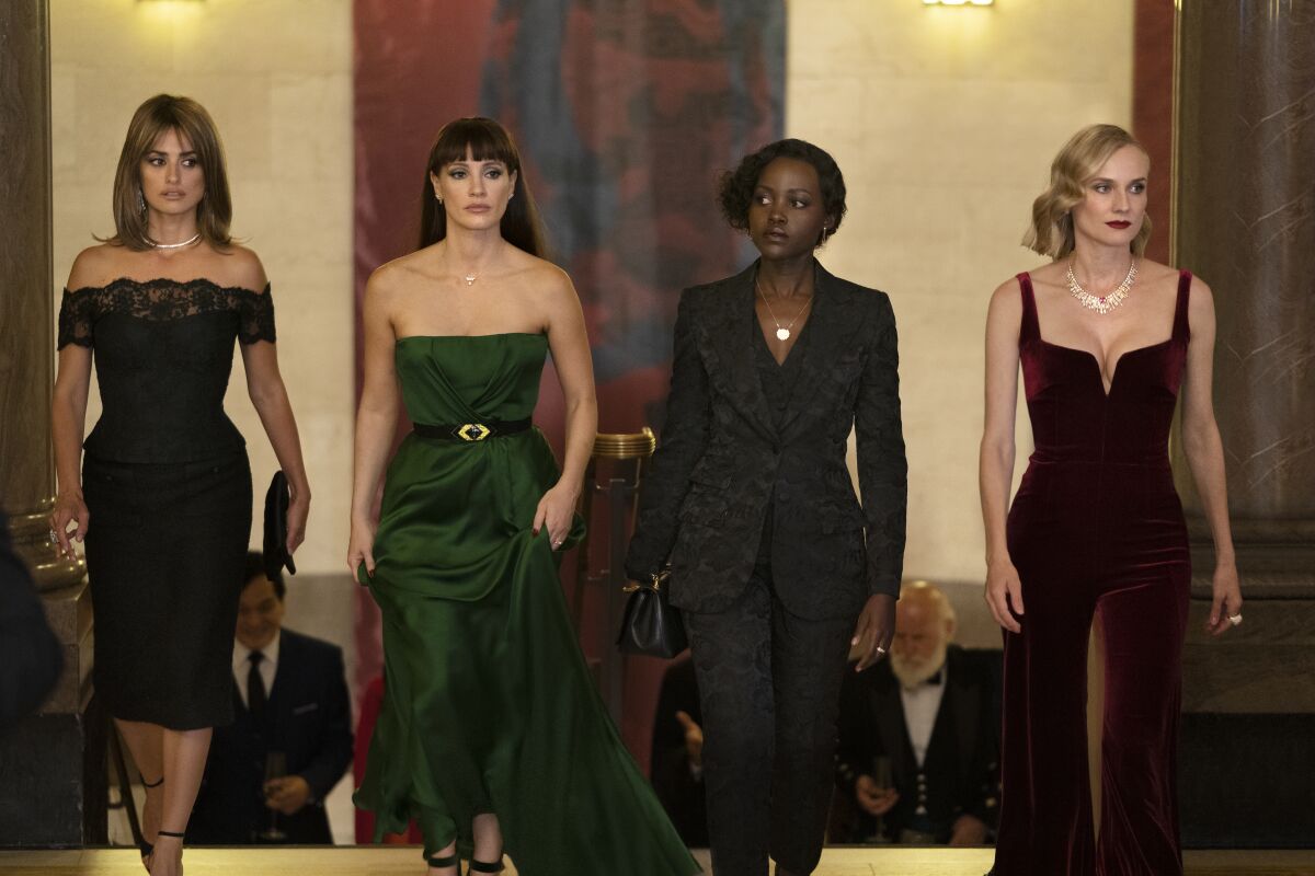Four women in evening dress walk together in the movie "The 355."
