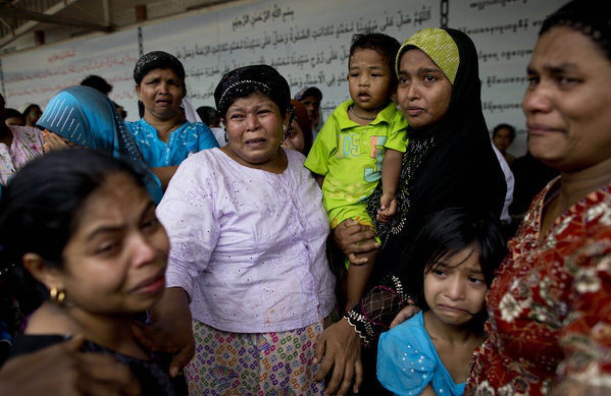 Women cry during burials of the victims of a mosque fire on the outskirts of Yangon, Myanmar.