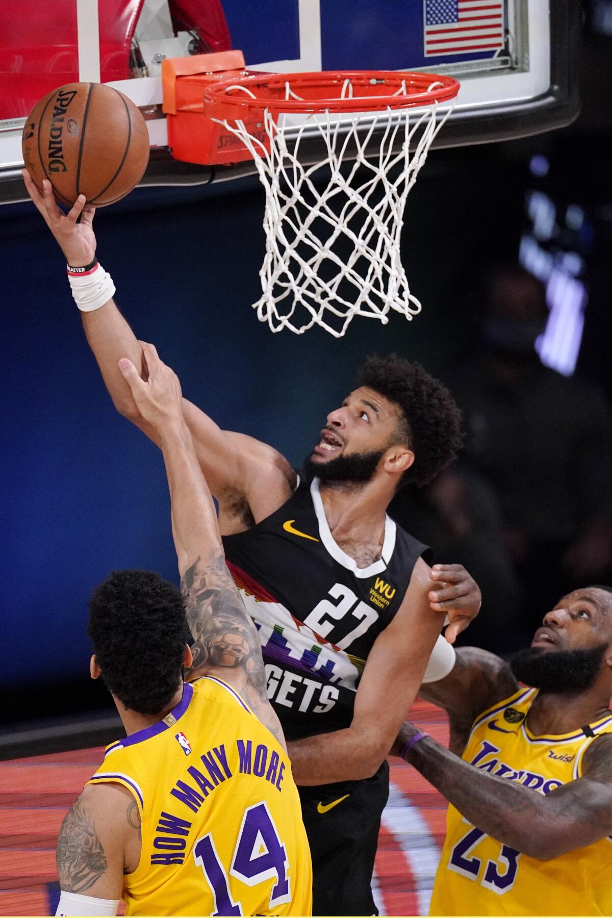 Nuggets guard Jamal Murray drives to the basket against Lakers guard Danny Green and forward LeBron James during Game 4