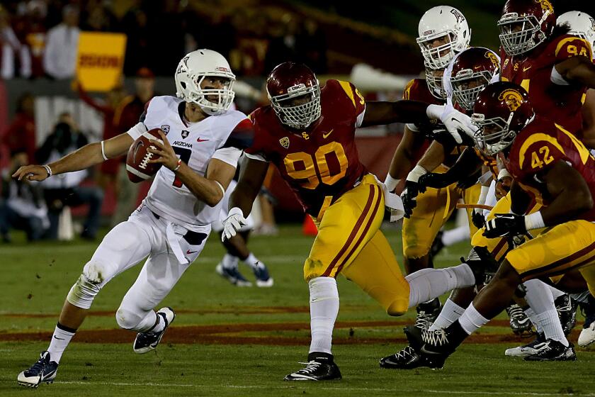 Then-USC defensive end George Uko (90) flushes Arizona quarterback B.J. Denker out of the pocket during a game on Oct. 10, 2013.