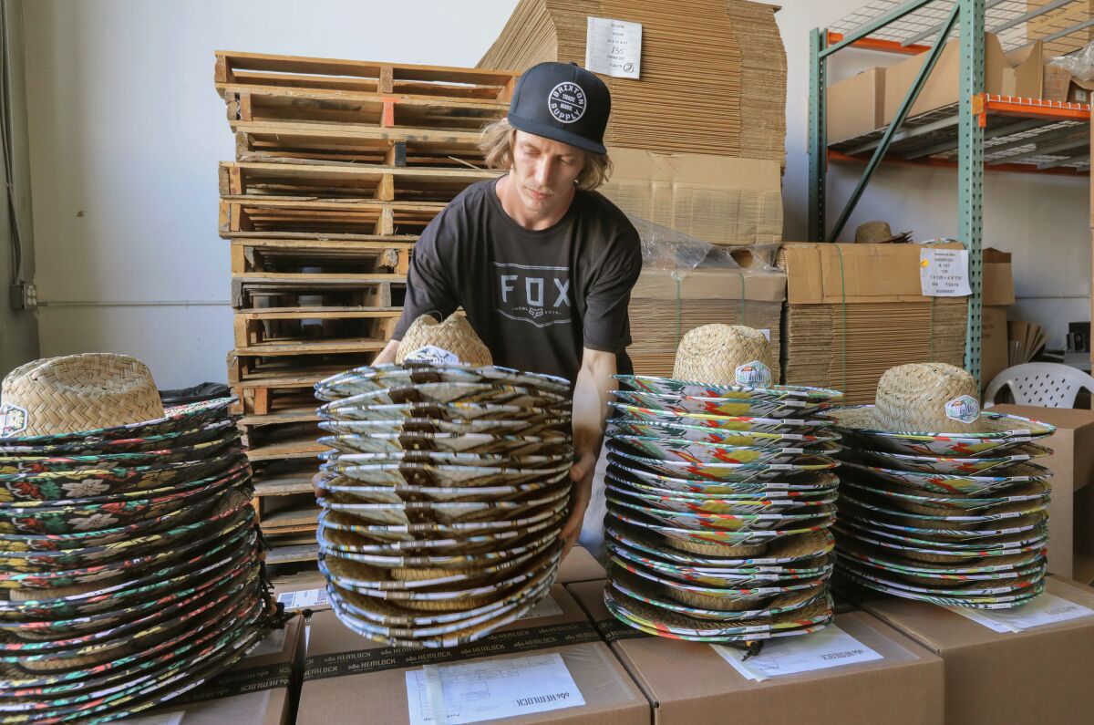 At Hemlock Hat Co. warehouse employee Randy Lawson prepares stacks of hats for shipping.