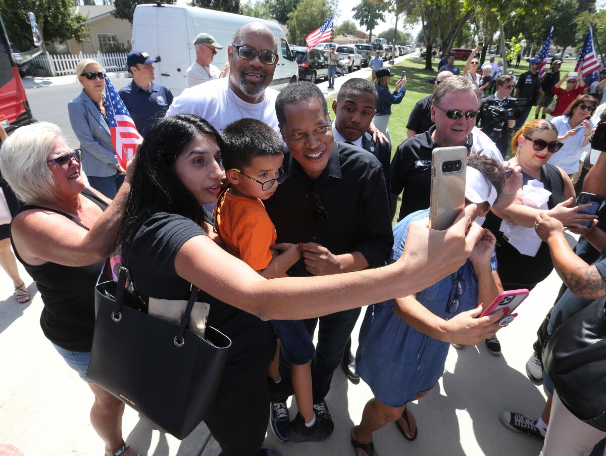 A woman and her 5-year-old son take a photograph with gubernatorial candidate Larry Elder in Bakersfield.